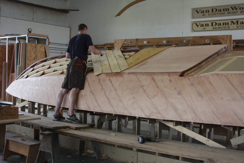 Craftsman adding planking to hull of VZ